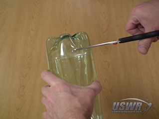 Roughly cut off the bottle about 1/4" on the discarded side of the cut line to make the final cut easier.