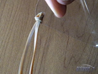Tie a long rubber band to the corner of the Parachute Cover.