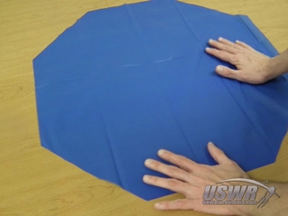 The material is unfolded to reveal a perfect octagon.