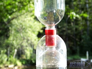 A portion of a bottle end is positioned over the Tornado Tube to provide an enclosure for the trigger mechanism. This prevents the parachute from tangling in the mechanism.