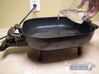 Pour clean water into a pan or skillet and start to warm the water.