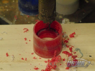 A 3/4" hole saw in a drill is used to cut the holes through the couplers.